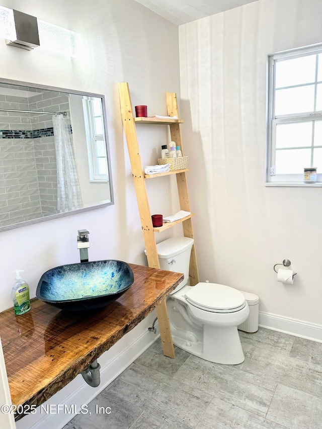 bathroom with sink, a shower with curtain, and toilet