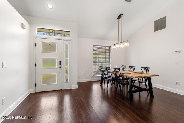 interior space with dark wood-style floors, visible vents, vaulted ceiling, and baseboards