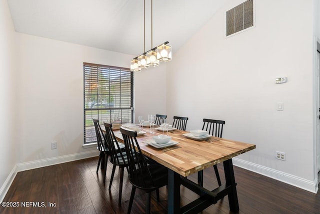 dining room featuring lofted ceiling, dark wood-style floors, baseboards, and visible vents