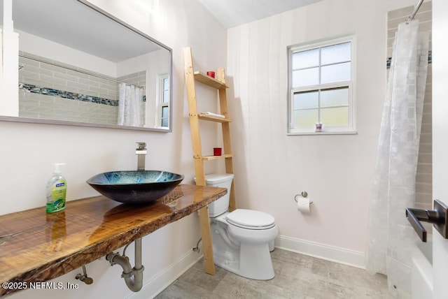 bathroom featuring baseboards, a sink, and toilet