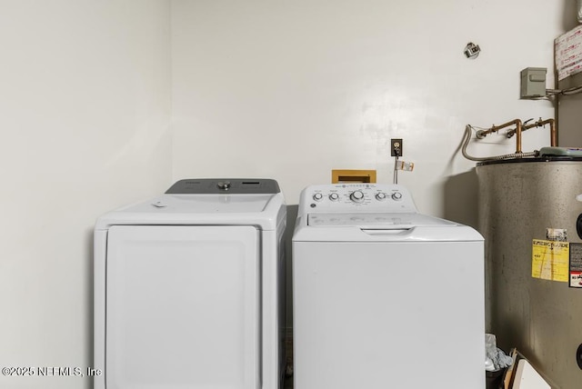 washroom featuring laundry area, water heater, and washer and clothes dryer