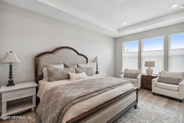 bedroom with a textured ceiling and light hardwood / wood-style floors