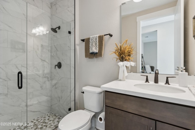 bathroom with vanity, toilet, and a shower with door