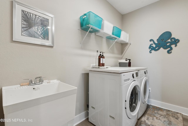 clothes washing area featuring independent washer and dryer and sink