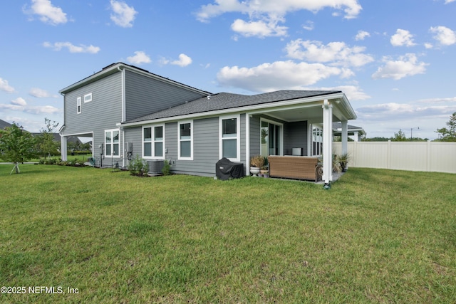 rear view of property with a yard and central air condition unit