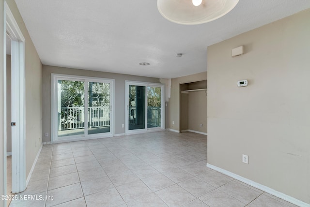 tiled empty room featuring a textured ceiling