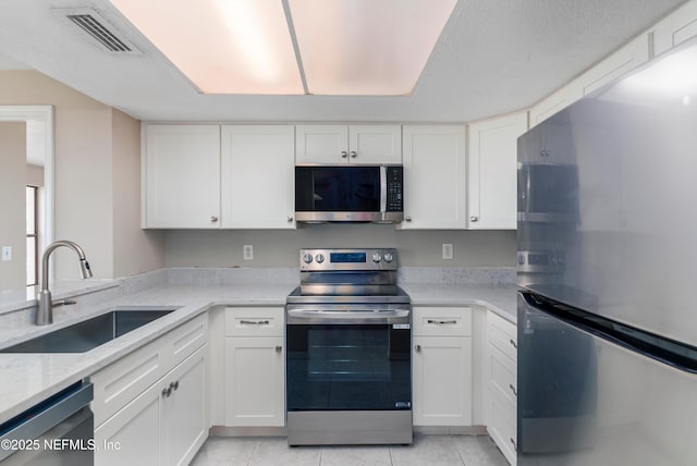 kitchen featuring stainless steel appliances, white cabinetry, and sink