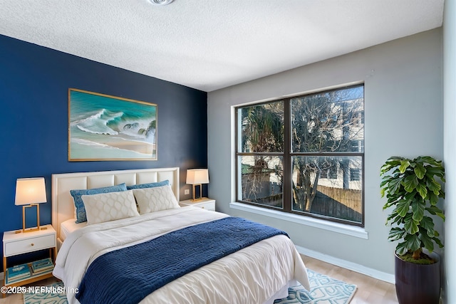 bedroom featuring a textured ceiling and light wood-type flooring