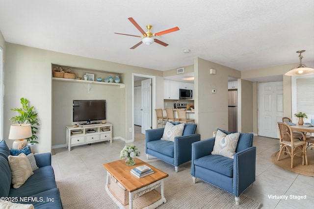 tiled living room featuring ceiling fan