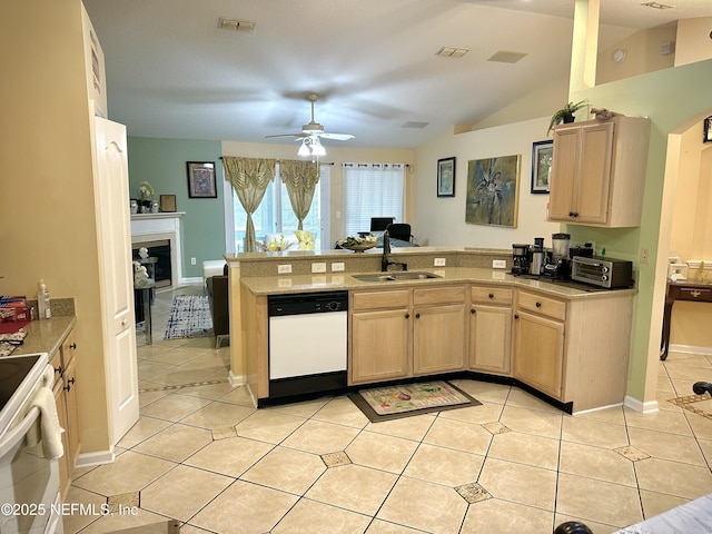 kitchen featuring vaulted ceiling, light brown cabinetry, sink, light tile patterned floors, and white appliances