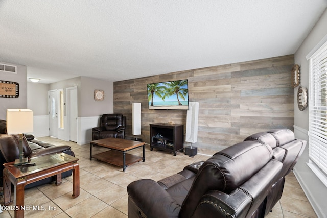 tiled living room featuring wooden walls and a textured ceiling