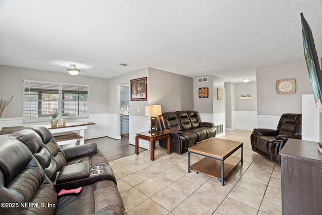 living room with light tile patterned flooring and a textured ceiling