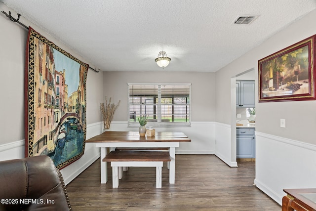 dining room with dark hardwood / wood-style floors and a textured ceiling