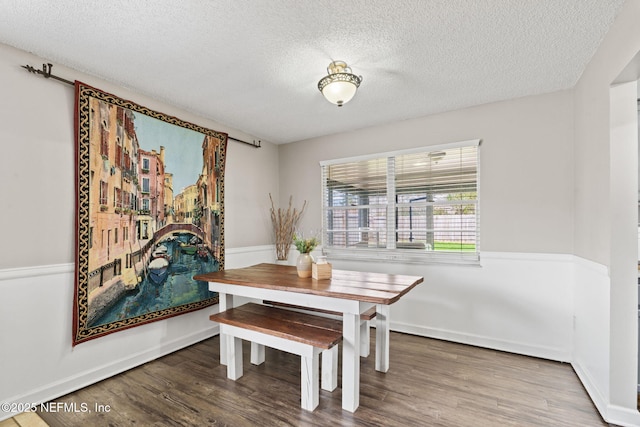 dining area with hardwood / wood-style flooring, a fireplace, and a textured ceiling