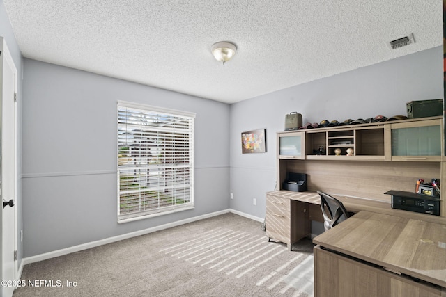 carpeted home office with a textured ceiling