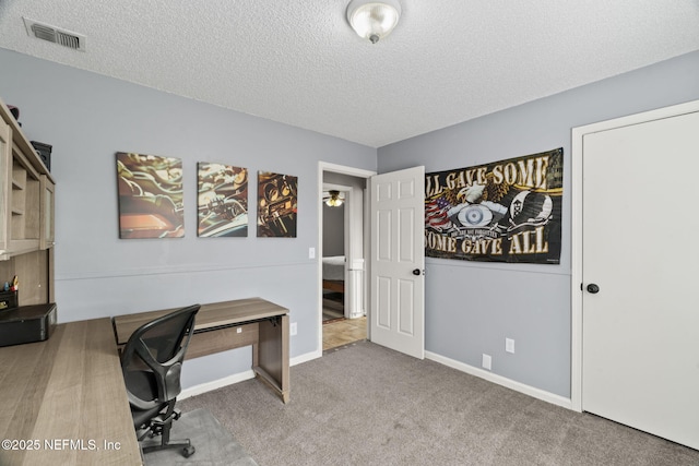 carpeted office with a textured ceiling