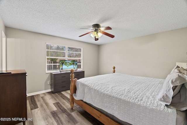 bedroom featuring ceiling fan, light hardwood / wood-style flooring, and a textured ceiling