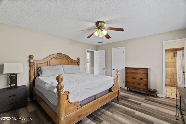 bedroom featuring connected bathroom, wood-type flooring, a textured ceiling, and ceiling fan