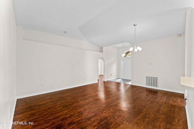 unfurnished living room with an inviting chandelier, wood-type flooring, vaulted ceiling, and a textured ceiling