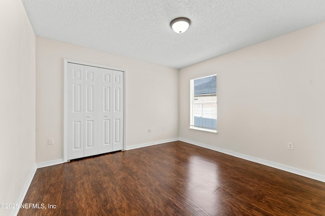 unfurnished bedroom featuring dark hardwood / wood-style flooring, a closet, and a textured ceiling