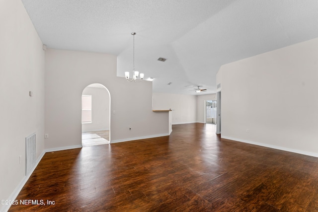 interior space featuring lofted ceiling, dark hardwood / wood-style floors, ceiling fan with notable chandelier, and a textured ceiling