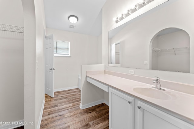 bathroom featuring a tub to relax in, vanity, and wood-type flooring