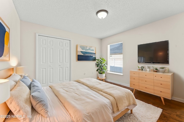 bedroom with a textured ceiling, dark hardwood / wood-style flooring, and a closet