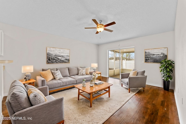 living room with ceiling fan, dark hardwood / wood-style floors, and a textured ceiling