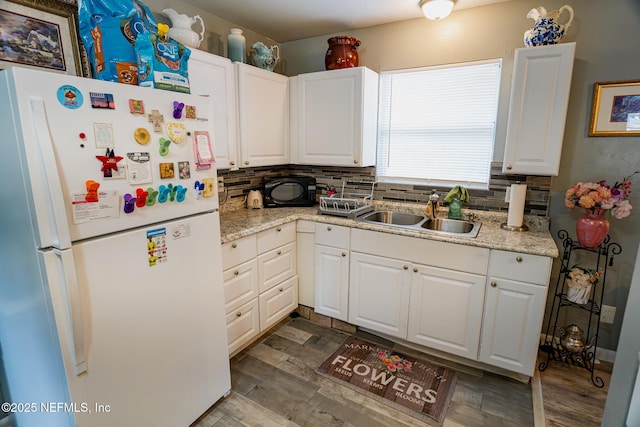 kitchen featuring white cabinetry, decorative backsplash, sink, and white fridge