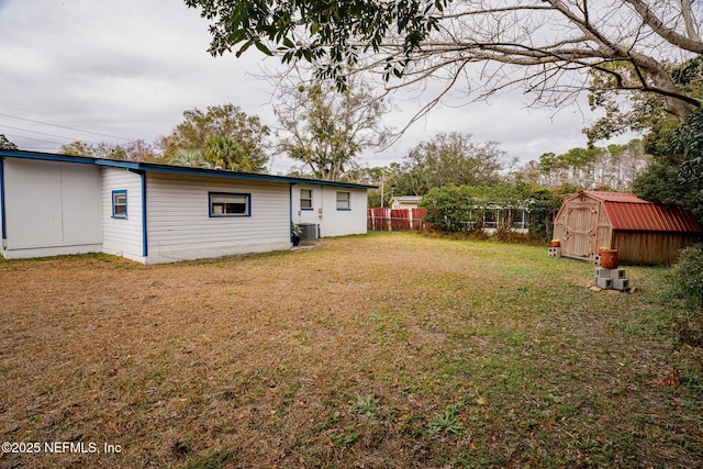 view of yard featuring central AC unit and a shed