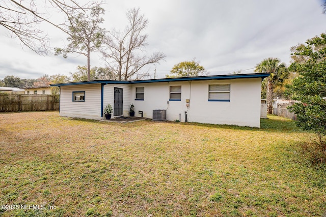 rear view of house with a yard and central air condition unit