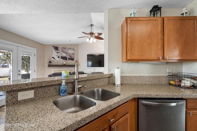 kitchen featuring sink, stainless steel dishwasher, light stone counters, kitchen peninsula, and a textured ceiling