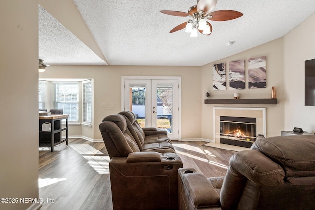 living room featuring lofted ceiling, hardwood / wood-style flooring, a wealth of natural light, and french doors