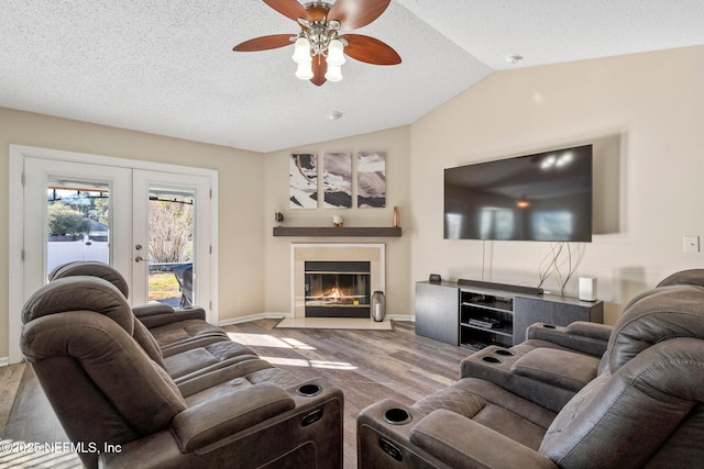 living room with hardwood / wood-style flooring, lofted ceiling, french doors, and a textured ceiling