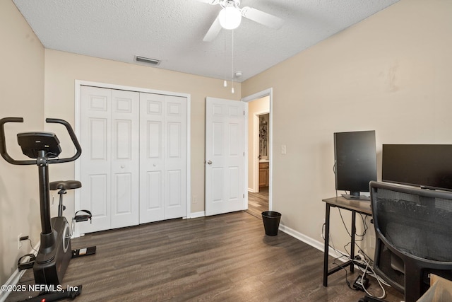 home office featuring ceiling fan, dark wood-type flooring, and a textured ceiling