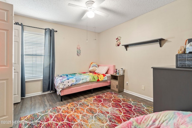 bedroom featuring dark wood-type flooring, ceiling fan, and a textured ceiling