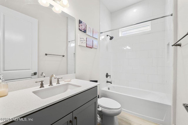 full bathroom featuring vanity, wood-type flooring, toilet, and tiled shower / bath