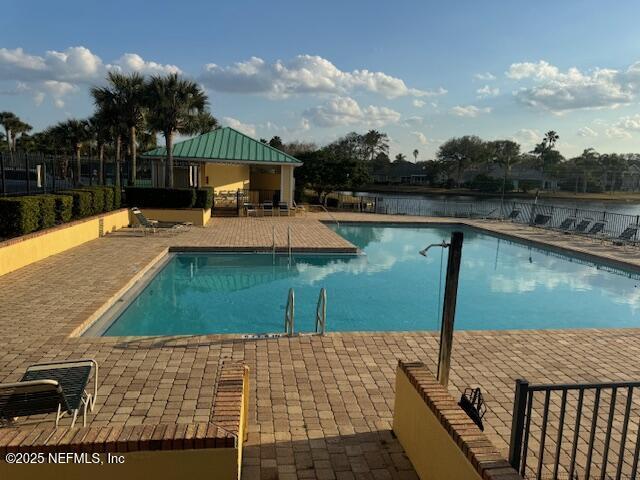 view of pool with a gazebo, a water view, and a patio area