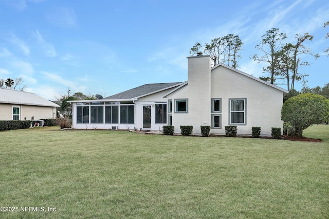 back of house with a sunroom and a lawn