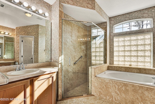 bathroom with tile patterned floors, vanity, independent shower and bath, and a textured ceiling