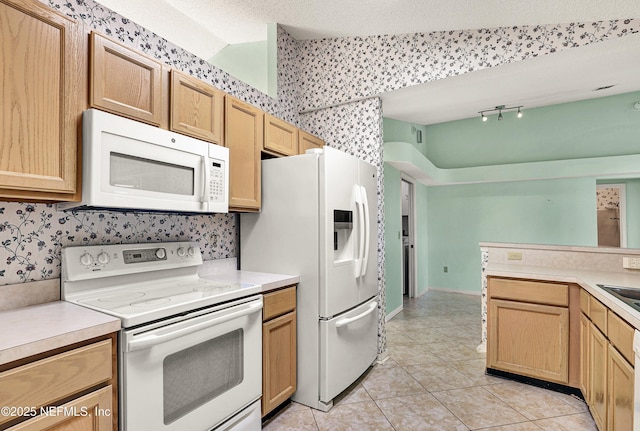 kitchen with light tile patterned floors, a textured ceiling, and white appliances