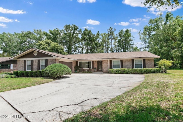 ranch-style house with brick siding, a garage, a front yard, and concrete driveway