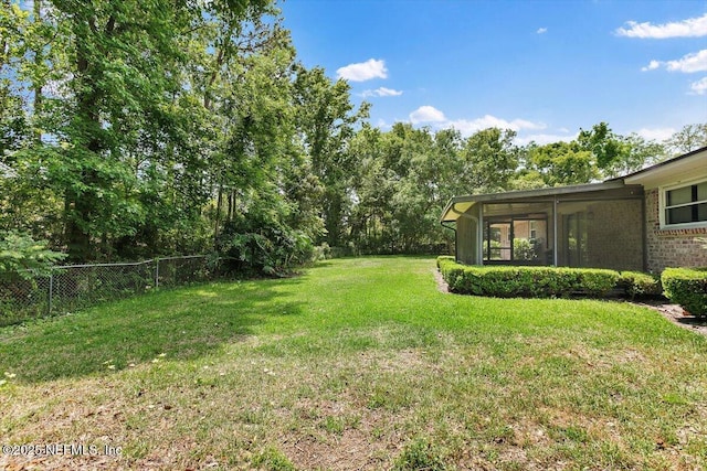 view of yard with fence and a sunroom
