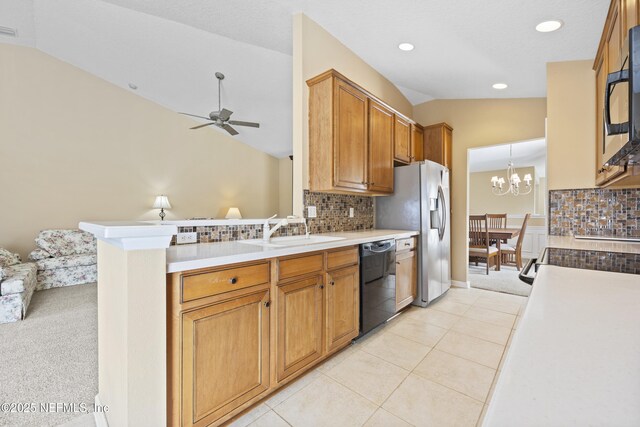 kitchen featuring sink, decorative light fixtures, vaulted ceiling, kitchen peninsula, and black appliances