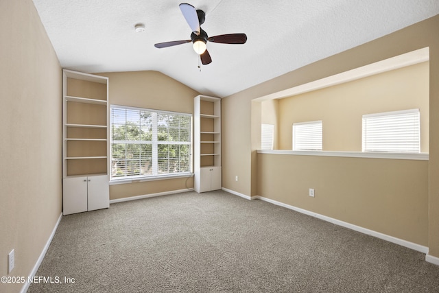 unfurnished bedroom with lofted ceiling, ceiling fan, a textured ceiling, and carpet flooring