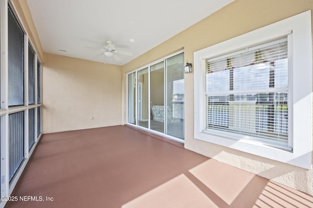 unfurnished sunroom with ceiling fan