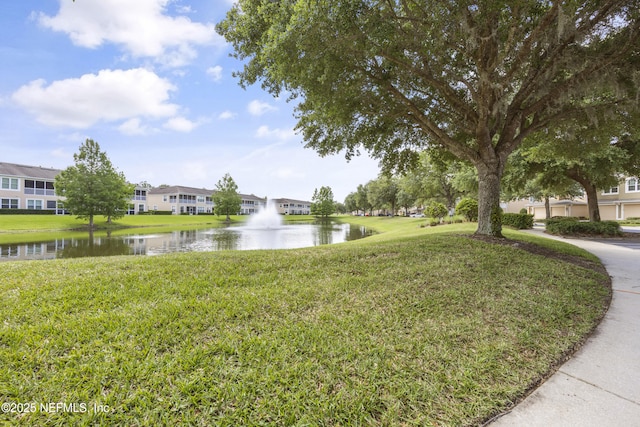 view of property's community featuring a water view and a yard