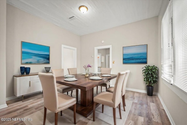 dining room with baseboards, visible vents, and light wood-style floors