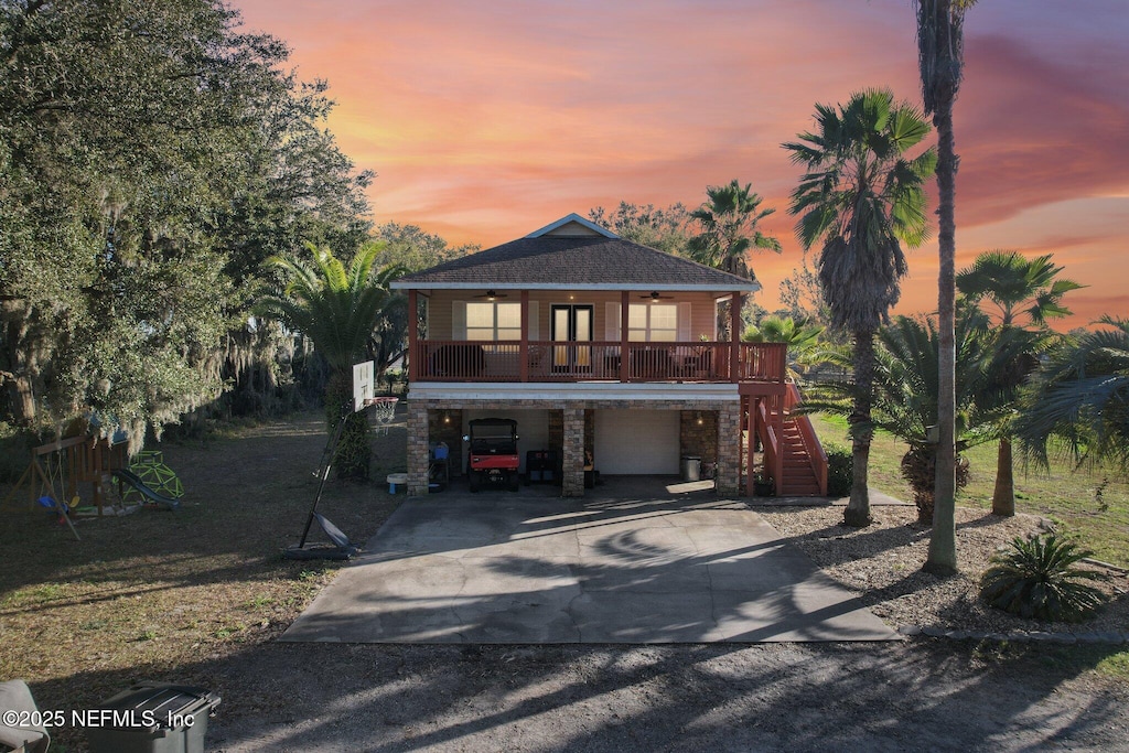 view of front of home with a carport, a garage, a porch, and ceiling fan