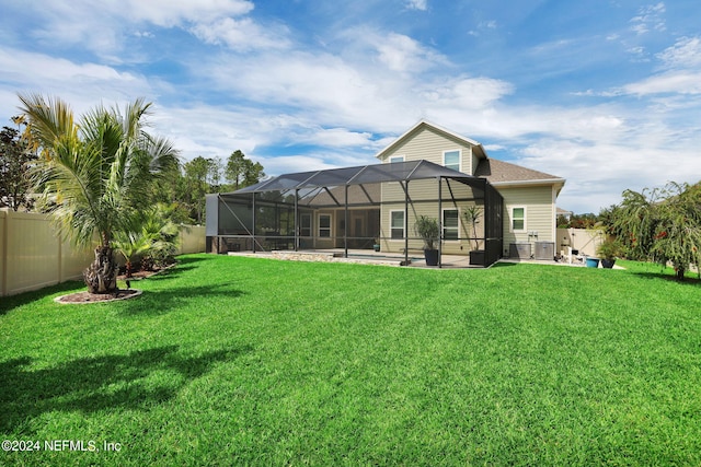 back of house featuring a yard, a lanai, and a patio area